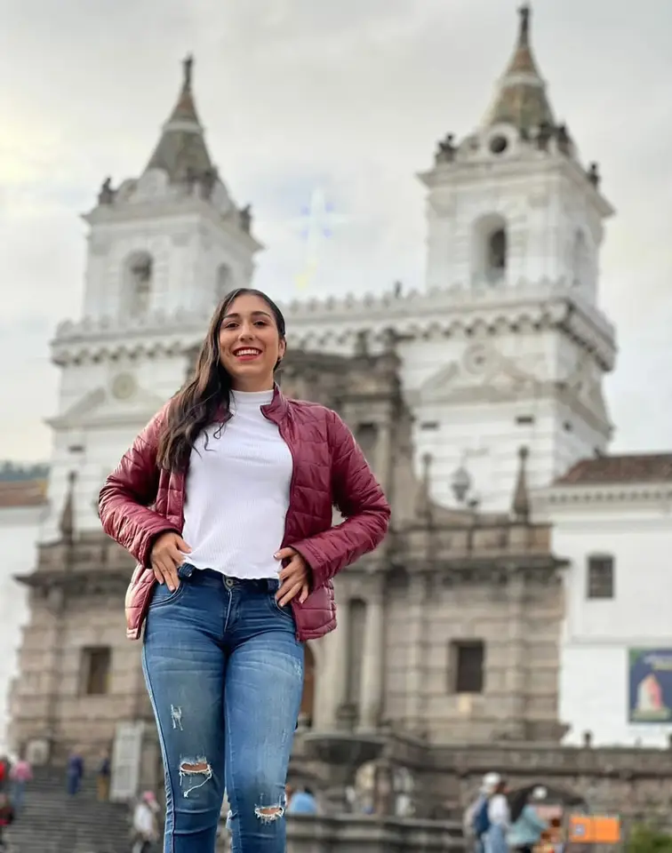 Liliana posa frente a una iglesia de dos torres.