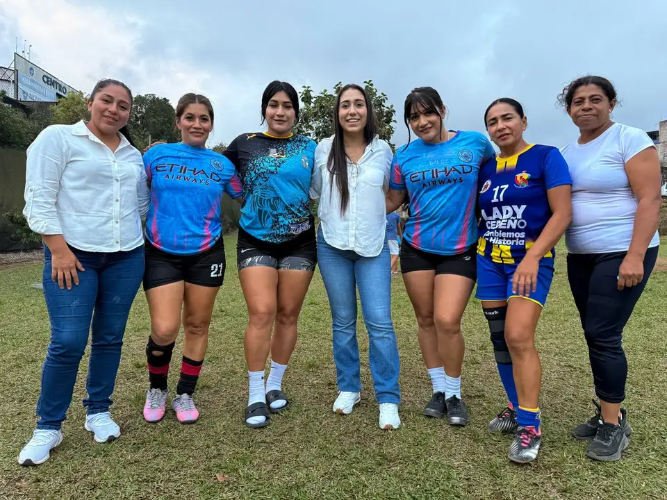 Participantes de un campeonato femenino posan con camisetas deportivas.