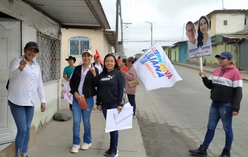 Grupo de personas camina por una calle con banderas de la Alternativa.