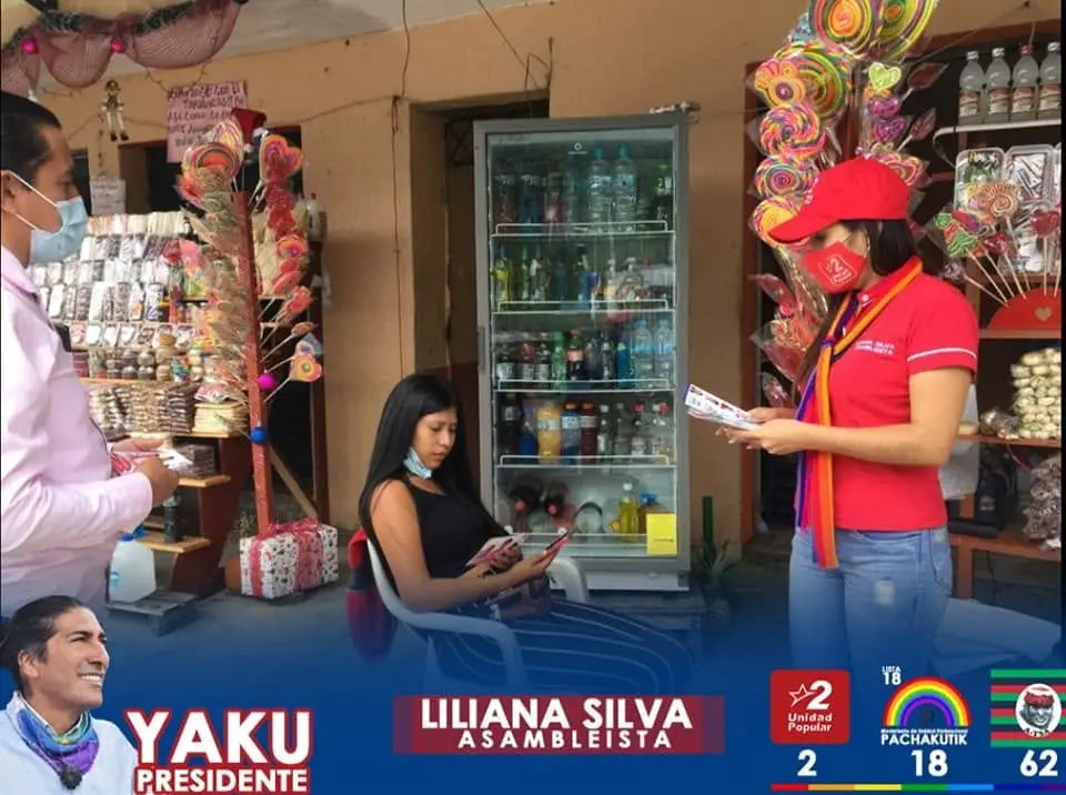 Personas conversan dentro de un local con dulces decorativos; una sostiene folletos.