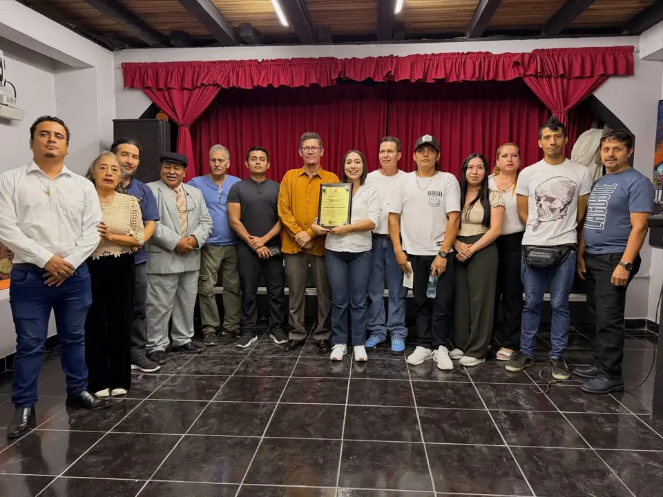 Personas reunidas durante una actividad cultural en un escenario.