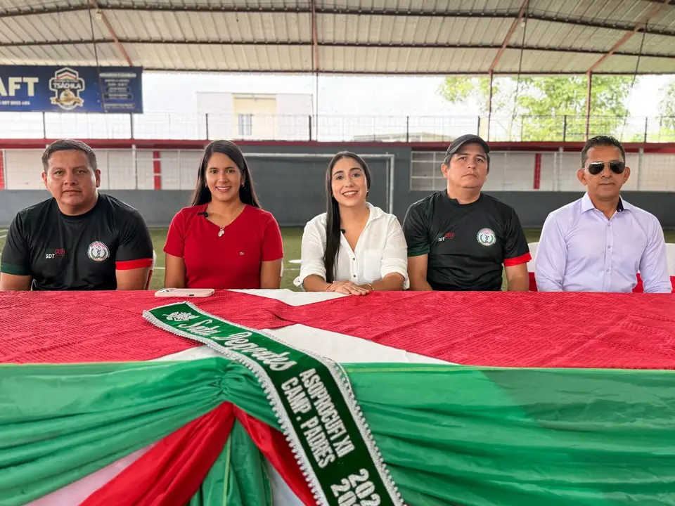 Participantes de una jornada deportiva posan frente a una instalación cubierta.