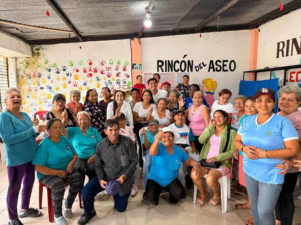 Grupo de adultos mayores posa en un espacio comunitario.