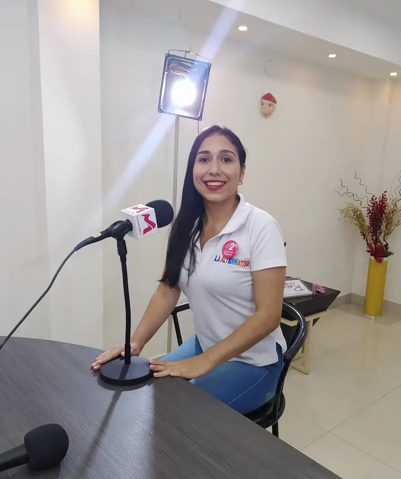 Liliana sentada ante un micrófono de radio.