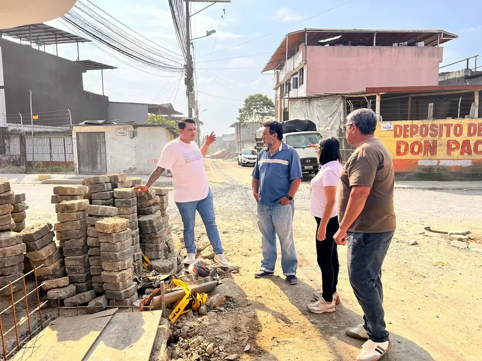 Personas observan una zona abierta con bloques y materiales de construcción.